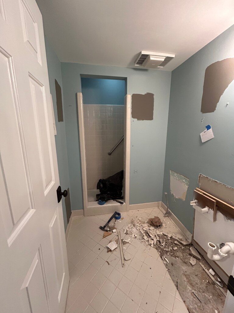 A dated bathroom stripped back to the subfloor before remodeling